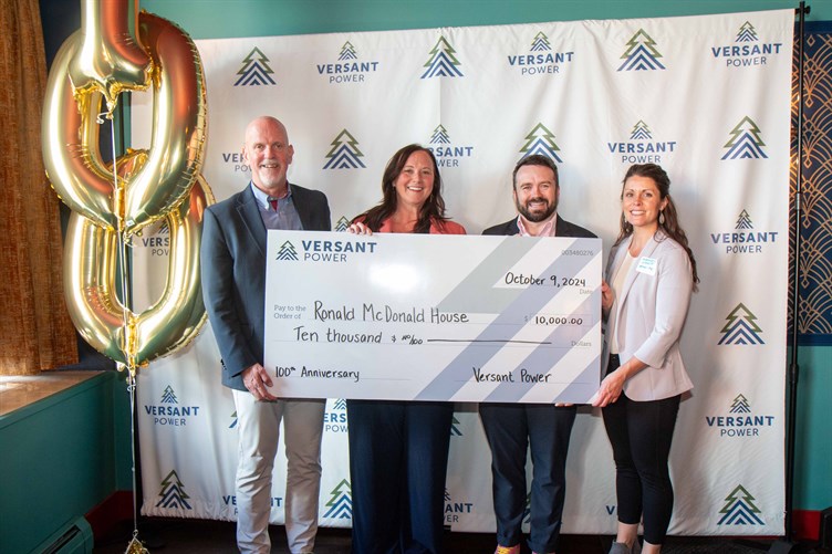 4 people posing with large donation check