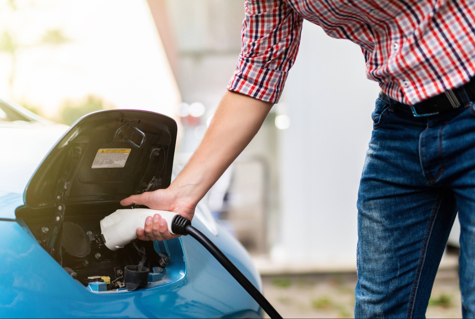 person plugging in electric car